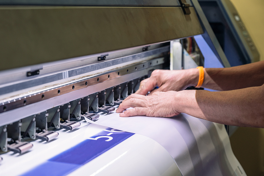 Técnico sacando un papel vinilo de impresora